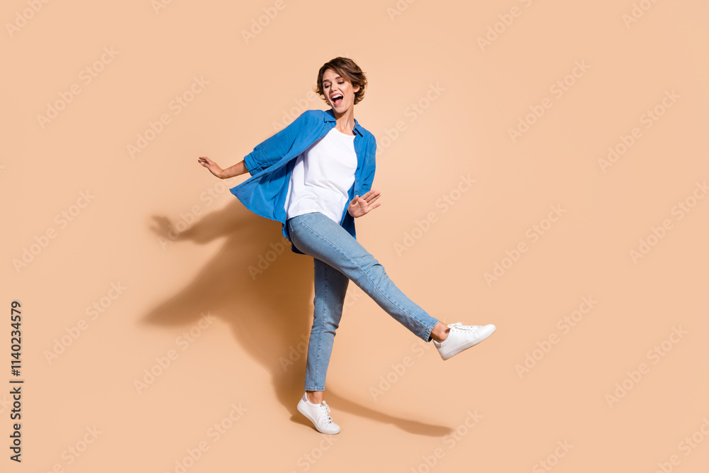 Full body length photo of young funky overjoyed business woman in smart casual clothes dancing isolated on beige color background Full body length photo of young funky overjoyed business woman in smart casual clothes dancing isolated on beige color background