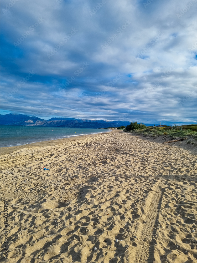 Sandy beach with tire tracks under a cloudy sky Sandy beach with tire tracks under a cloudy sky