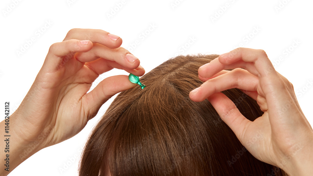 Fototapeta premium Close-up of woman applying serum capsule on her head skin, hair against white studio background. Treatment, nourishment. Concept of natural beauty, hair care, cosmetics and cosmetology