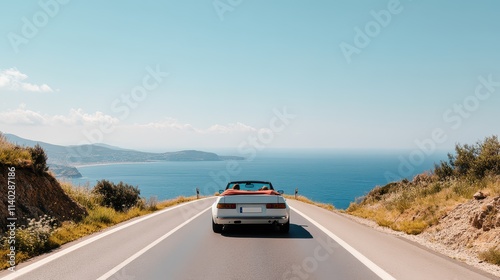 A scenic drive along a coastal road, showcasing a car against a stunning ocean backdrop under a clear blue sky. photo