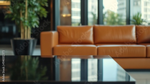 Close-up of an empty black table in a warm lobby with a brown leather couch in the background