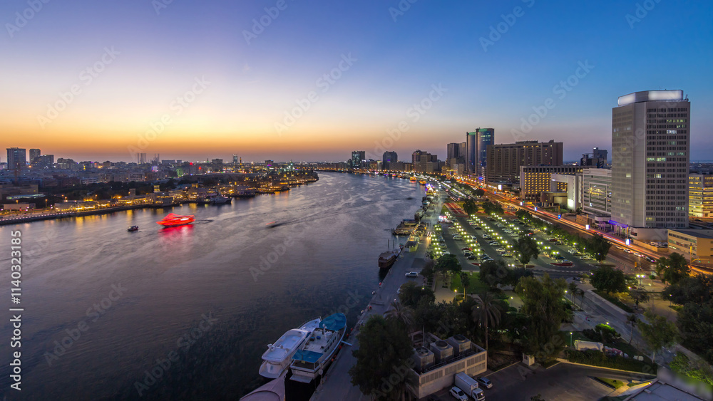 Obraz premium Dubai creek landscape day to night timelapse with boats and ship near waterfront