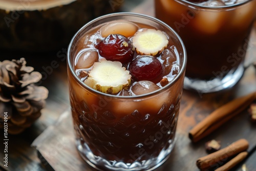 Sujeonggwa is a traditional Korean cinnamon drink dark reddish brown made with cinnamon dried persimmon and ginger topped with pine nuts and jujube photo