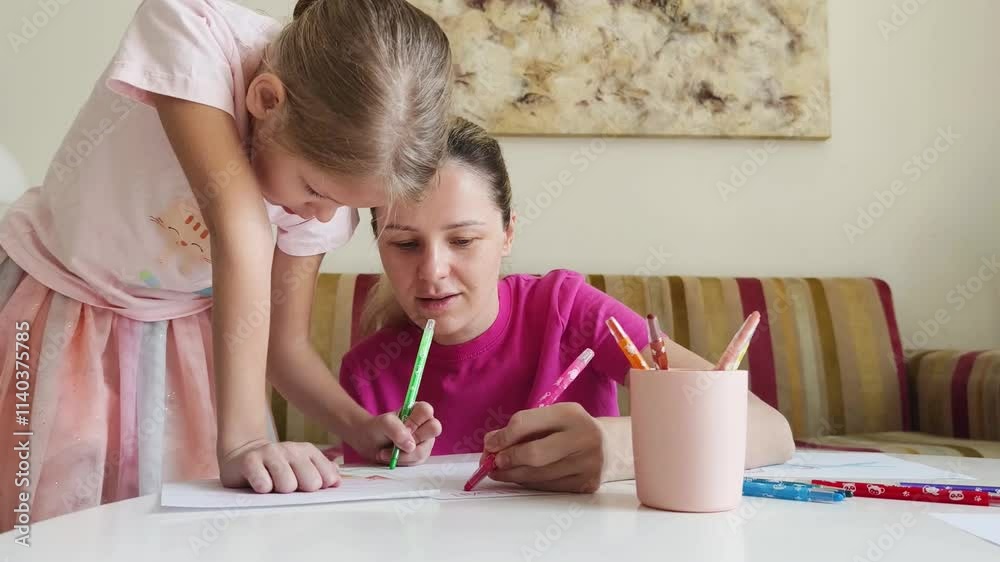 A mother and daughter are engaging in coloring activities A mother and daughter are engaging in coloring activities