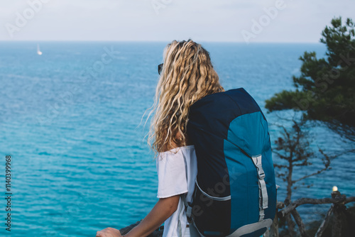 Bilde på lerret Back view of female explorer with travel backpack enjoying natural environment o