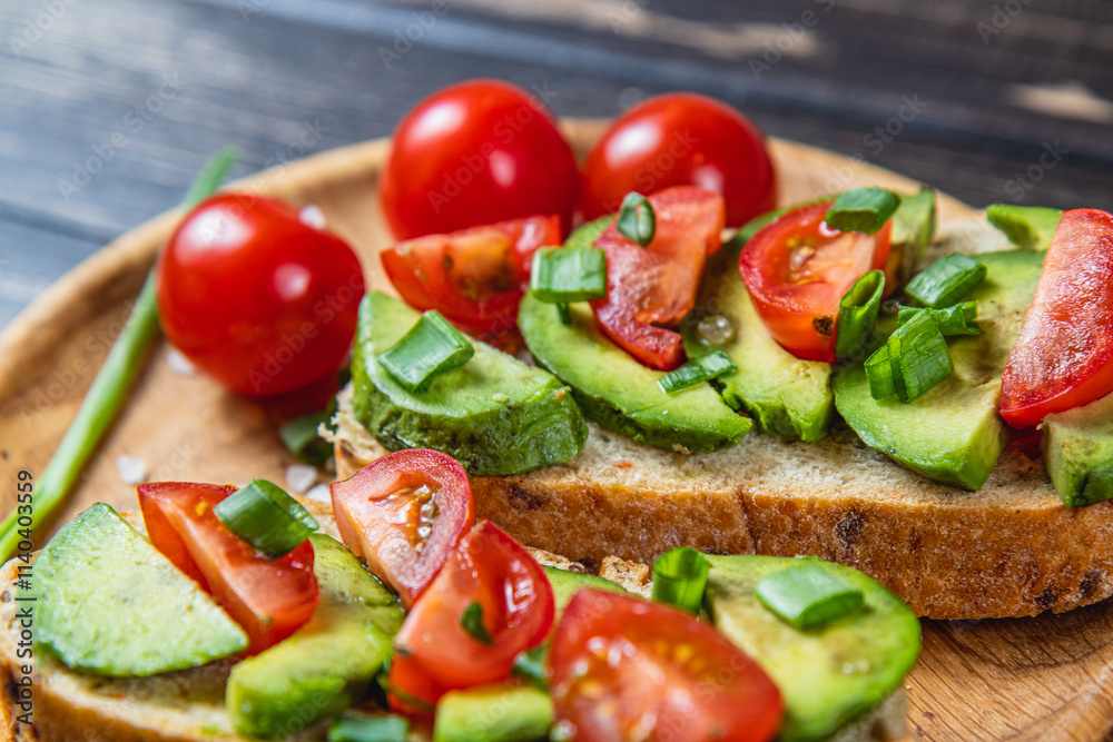 Avocado toast topped with tomato and green onion on a slice of carrot bread Avocado toast topped with tomato and green onion on a slice of carrot bread
