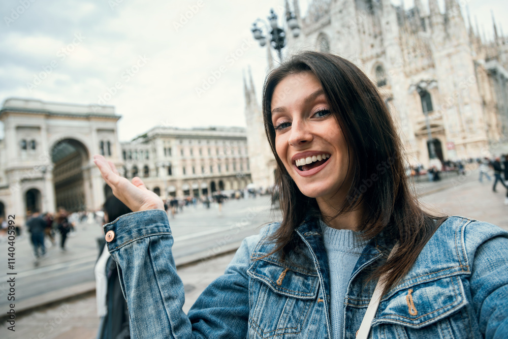 Beautiful taking pictures of herself with her smartphone while sightseeing on the streets of Milan city Beautiful taking pictures of herself with her smartphone while sightseeing on the streets of Milan city