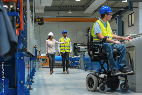 Factory woman CEO touring with an employee the production line, where another worker with a disability expertly completing his tasks.