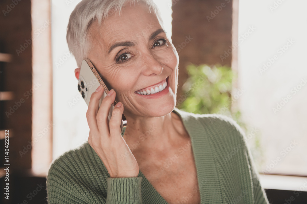 Elderly woman smiling warmly while talking on phone in a cozy living room ambiance Elderly woman smiling warmly while talking on phone in a cozy living room ambiance