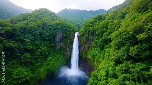 Majestic waterfall cascading through lush green mountains.