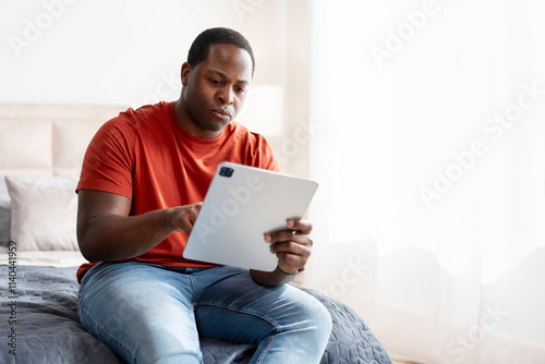 Portrait of African American freelancer man using digital tablet while working at home