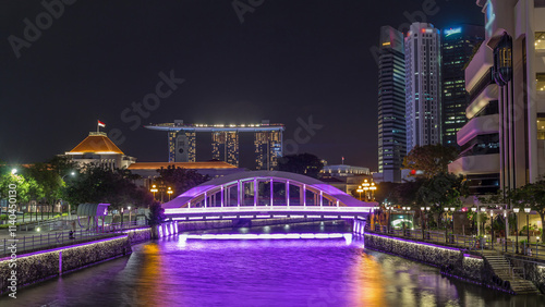 Skyline of Singapore financial district behind Elgin Bridge and the Singapore River night timelapse hyperlapse photo