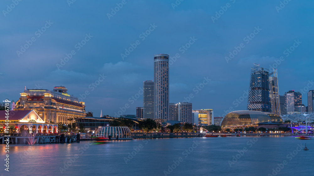 Fototapeta premium City skyline with skyscrapers and Esplanade Theatres on the Bay in Singapore at dusk, with beautiful reflection in water day to night timelapse