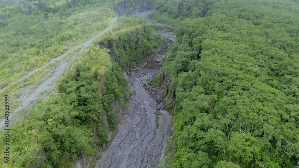 Aerial View of Dramatic Sand Mining Activity in Volcanic Lava Gorge Amid Foggy and Overcast Skies Aerial View of Dramatic Sand Mining Activity in Volcanic Lava Gorge Amid Foggy and Overcast Skies