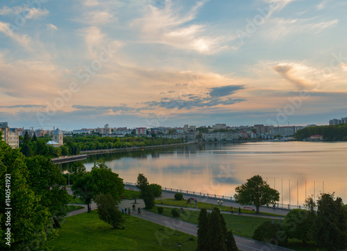 Panoramic view of a beautiful lake, embankment with trees in the park under t...