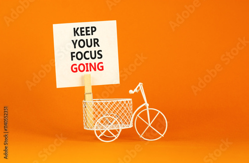 Keep your focus going symbol. Concept words Keep your focus going on beautiful white paper. Beautiful orange background. Miniature bicycle. Business and keep your focus going concept. Copy space. photo