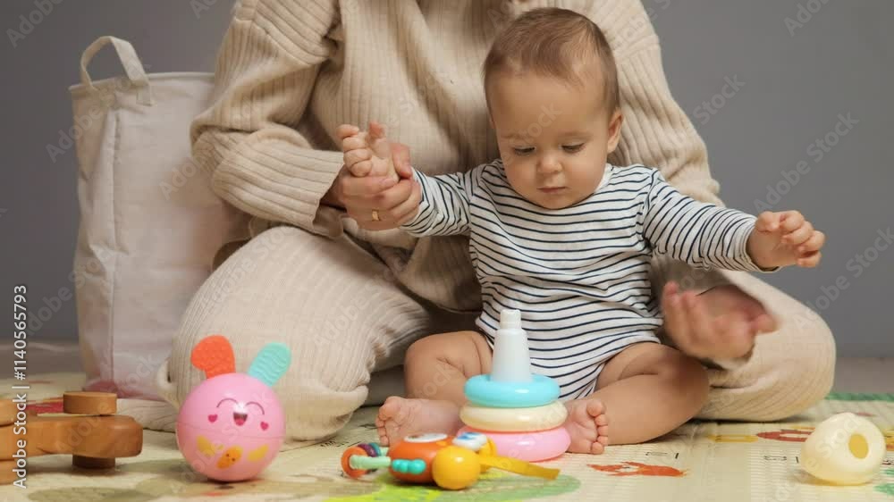 A young child engages with vibrant toys, exploring shapes and colors. A caregiver assists and encourages playtime in a cozy indoor setting, promoting early learning and development A young child engages with vibrant toys, exploring shapes and colors. A caregiver assists and encourages playtime in a cozy indoor setting, promoting early learning and development