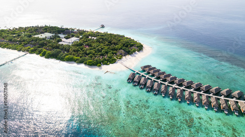 Obraz na płótnie Top view of the bungalow on the water. Maldives. Luxury villas near the green island. The view from the drone. Turquoise water, beautiful reef. The rays of the sun on the surface of the ocean. Waves w salonie