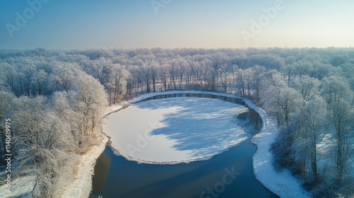 Snowy landscape with frozen pond and bare trees in winter