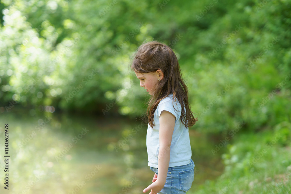 Little cute sad girl walking in summer park. Concept of sad child outdoors Little cute sad girl walking in summer park. Concept of sad child outdoors