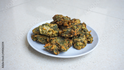 A plate of fried bakwan made from spinach with green color