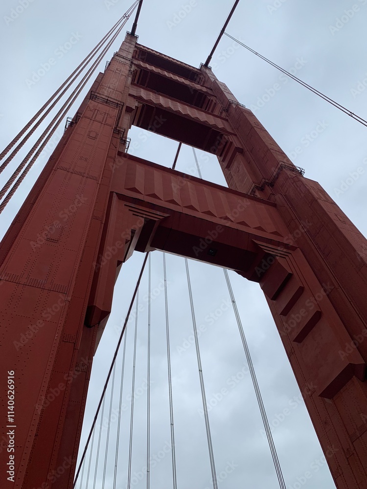 Naklejka premium This image captures a dramatic low-angle view of the Golden Gate Bridge in San Francisco.