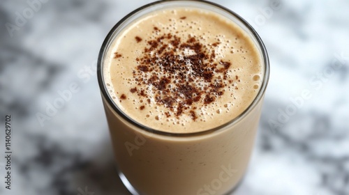 Creamy coffee drink topped with chocolate shavings served in a clear glass on...