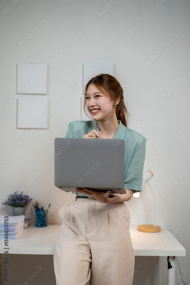 A woman is sitting at a desk with a laptop in front of her A woman is sitting at a desk with a laptop in front of her