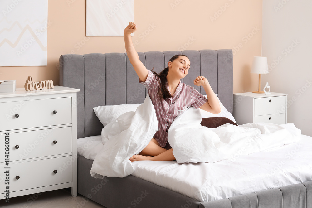 Morning of pretty young woman stretching on bed in bedroom Morning of pretty young woman stretching on bed in bedroom