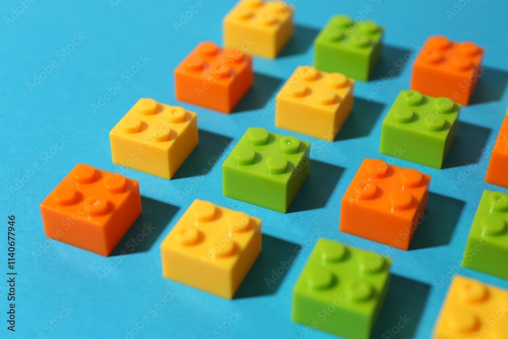 Construction toy. Colorful building bricks on light blue background, closeup Construction toy. Colorful building bricks on light blue background, closeup