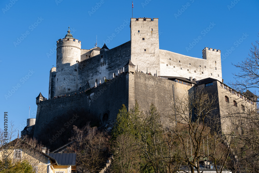 Fortress Hohensalzburg against a bright blue winter sky in the sunshine, on a hill. Salzburg Austria Fortress Hohensalzburg against a bright blue winter sky in the sunshine, on a hill. Salzburg Austria