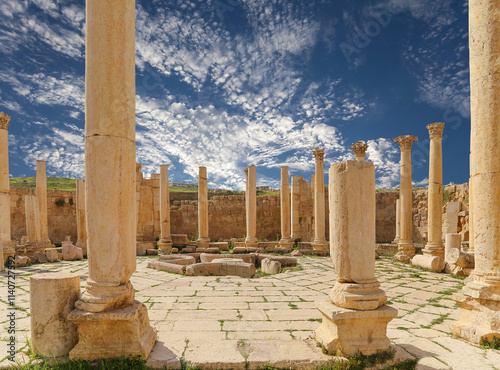 Roman ruins (against the background of a beautiful sky with clouds) in the Jordanian city of Jerash (Gerasa of Antiquity), capital and largest city of Jerash Governorate, Jordan #1140727592