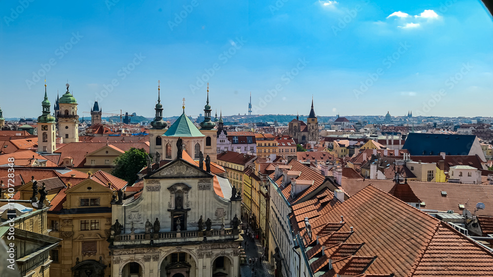 Fototapeta premium Breathtaking panoramic view of historic Old Town of Prague, Czechia. Red-tiled roofs of buildings create a vibrant tapestry. Tourist landmarks seen from tower of Charles bridge. Cityscape in summer