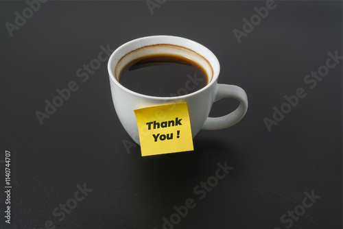A cup of coffee with a word Thank You on black background