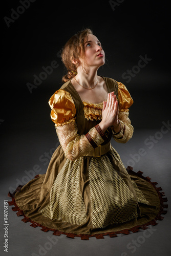 Medieval girl kneeling praying to her God