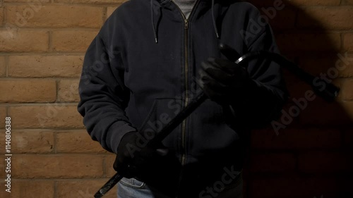 A threatening gangster holding a lug wrench