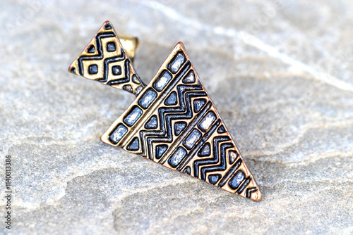 The geometric design earrings is isolated in the background.