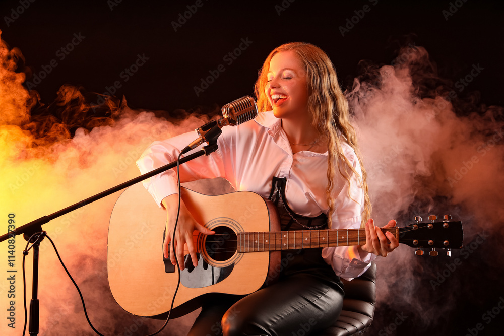 Beautiful young woman with microphone and guitar singing on dark background Beautiful young woman with microphone and guitar singing on dark background