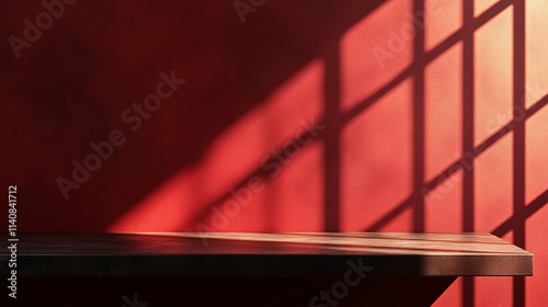 An empty table against a dark red wall, with natural light streaming through a window, creating shadows on the surface.