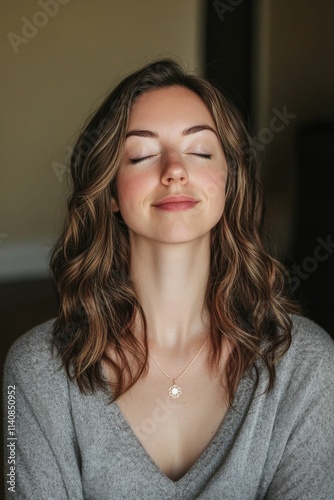 Serene woman, eyes closed, gray sweater, necklace.