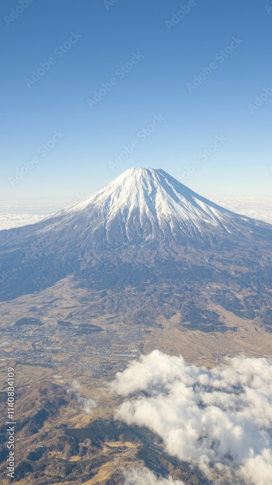 Aerial view of a snow-capped mountain under a clear blue sky. Aerial view of a snow-capped mountain under a clear blue sky.