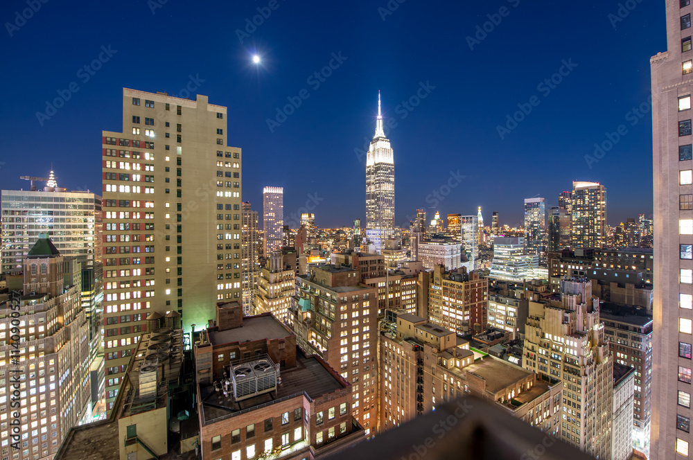 Fototapeta premium Aerial View of Manhattan Skyscrapers Illuminated at Night with Vibrant City Lights