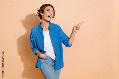 Photo of young lady entrepreneur pointing finger empty space gives useful tips for funny interns isolated on beige color background photo