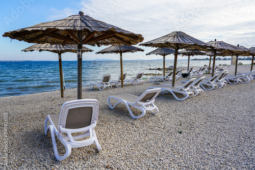 Empty beach cafe without visitors after the end of the season, reed sunshades, empty sunbeds photo