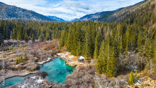 Zelenci Nature Reserve in winter transforms into a serene wonderland. Captured from the air, this breathtaking view showcases the emerald-green springs surrounded by a blanket of snow photo