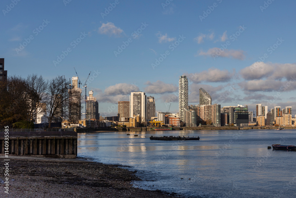Obraz premium London, UK – December 3, 2024, View from the other side of the Thames, from Canary Wharf at West India Docks, with skyscrapers.