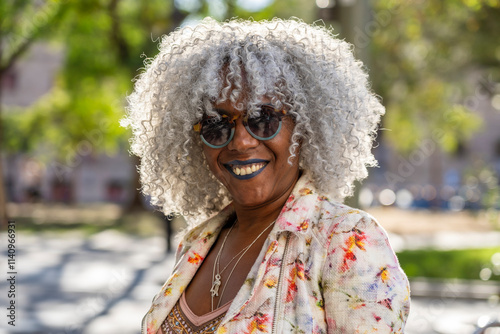 Stylish, smiling afro lady with grey afro hairstyle in sunny city photo