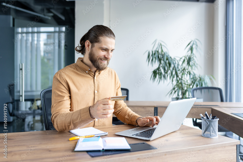 Professional worker using a laptop and holding a credit card. Represents online shopping, e-commerce, and modern business activities. Professional worker using a laptop and holding a credit card. Represents online shopping, e-commerce, and modern business activities.