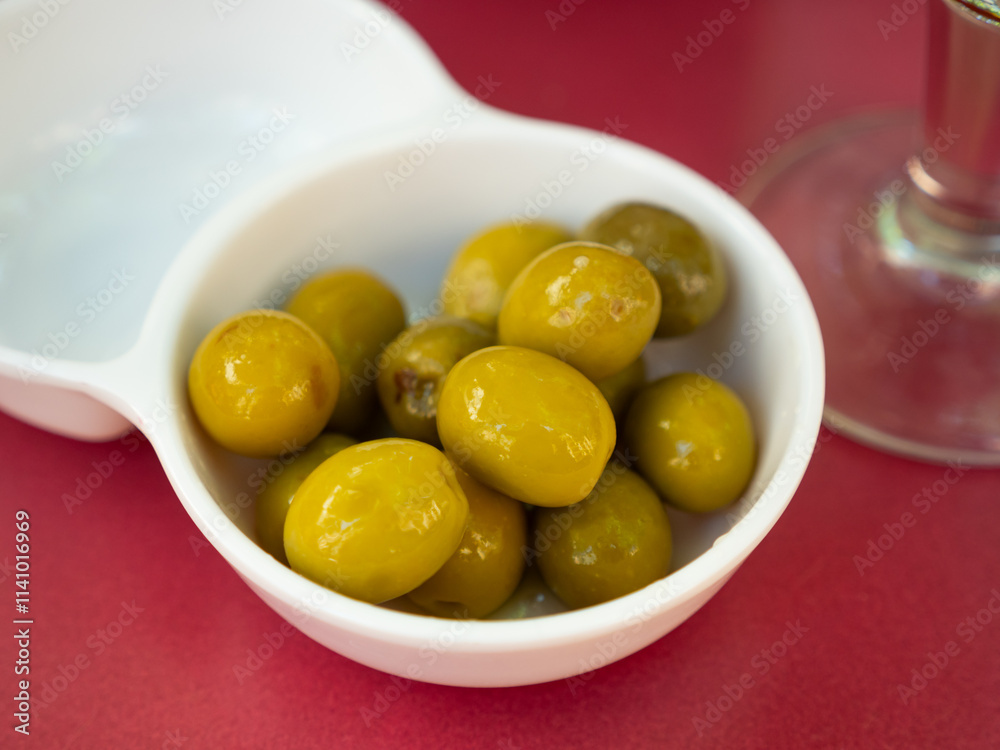Large green olives with pits served to table in bowl Large green olives with pits served to table in bowl