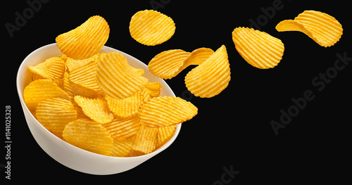 Falling ridged potato chips in bowl isolated on black background